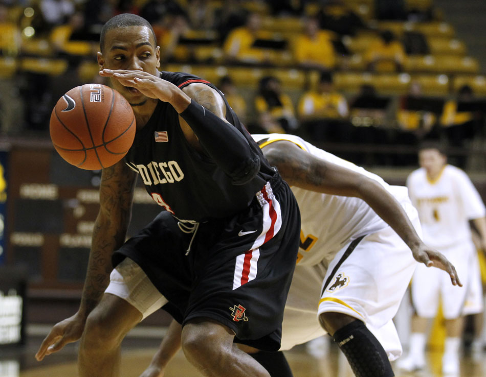 San Diego State forward Malcolm Thomas (4) regains control of the ball in front of a Wyoming defender during a NCAA men's basketball game on Tuesday, March 1, 2011, in Laramie, Wyo.