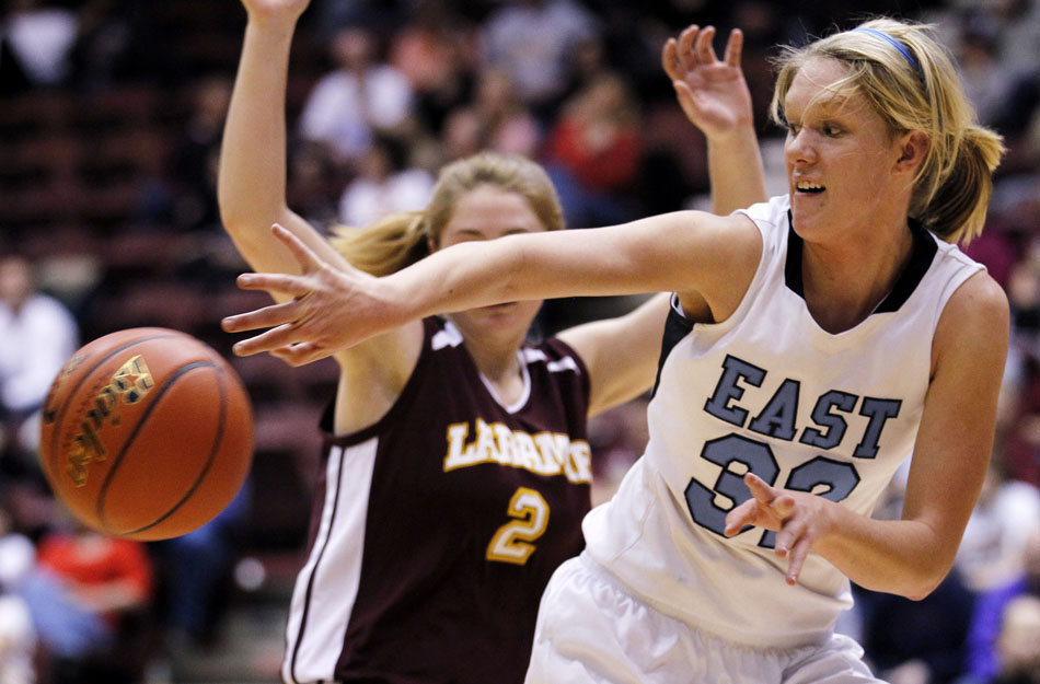 Cheyenne East's Meghan Sipe (32) passes to a teammate as she's guarded by Laramie's Kensie Harris (2) during a Class 4A girl's basketball consolation final on Saturday, March 12, 2011, in Casper, Wyo.