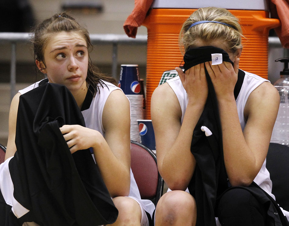 Cheyenne East's Meghan Sipe, right, puts her head in a towel as she sits on the bench with teammate Savannah Minder in the closing seconds of a 44-29 loss to Laramie in the Class 4A girl's basketball consolation final on Saturday, March 12, 2011, in Casper, Wyo.