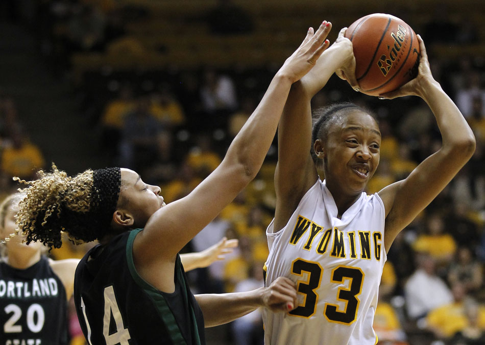 Wyoming forward Chaundra Sewell (33) looks to pass as she's guarded by a Portland State defender during a WNIT game on Wednesday, March 16, 2011, in Laramie, Wyo.