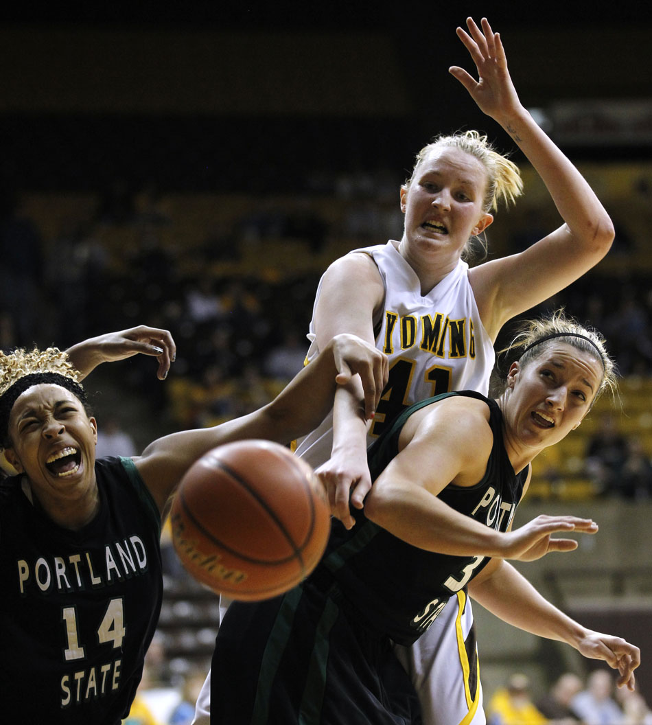 Portland State's Shauneice Samms (14) reacts as she goes after a rebound with teammate Lexi Bishop (33) and Wyoming forward Hillary Carlson (41) during a WNIT game on Wednesday, March 16, 2011, in Laramie, Wyo. Wyoming won and will play Oklahoma State on Monday in the second round.