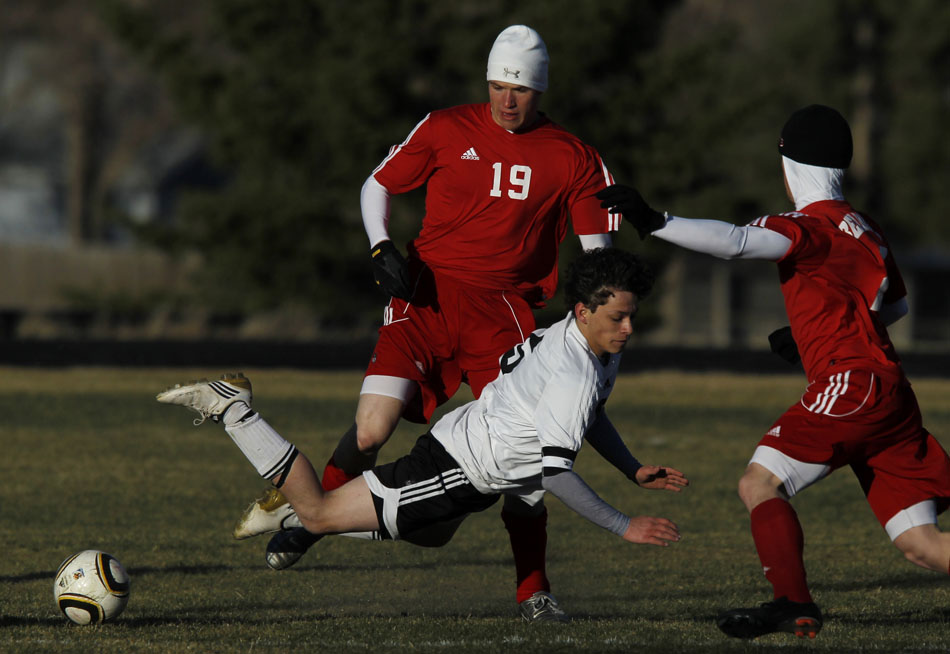 Cheyenne East's Jalen Willett falls to the pitch as he tries to advance the ball past Scottsbluff's Kyle Hertig (19) during a boy's soccer game on Tuesday, March 22, 2011, at Cheyenne East High School.
