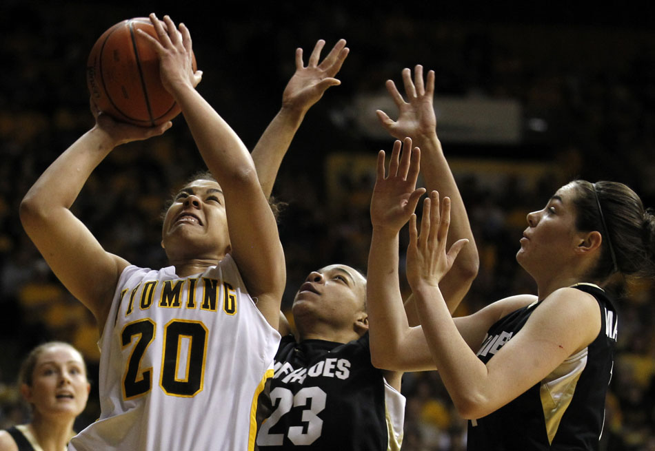 Wyoming's Aubrey Vandiver (20) goes in for a shot in front of Colorado's Chucky Jeffery (23) during a third round Women's NIT game on Thursday, March 24, 2011, in Laramie, Wyo.