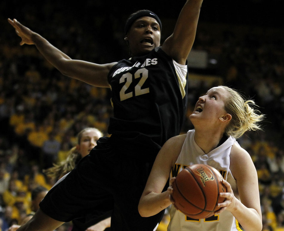 Wyoming's Hillary Carlson (41) looks to put up a shot as she gets Colorado's Brittany Spears (22) to leave the ground off of a shot fake during a third round Women's NIT game on Thursday, March 24, 2011, in Laramie, Wyo.