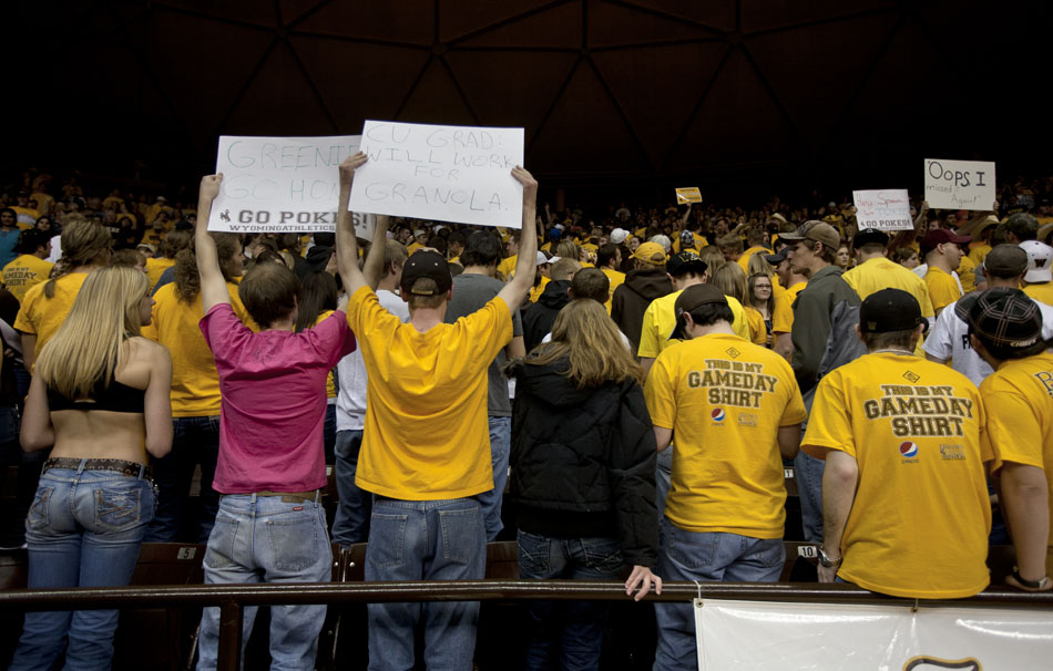 Wyoming fans in the student section turn their backs as the Colorado starting lineup is introduced during a third round Women's NIT game on Thursday, March 24, 2011, in Laramie, Wyo. The second sign from left reads "CU grad: will work for granola."