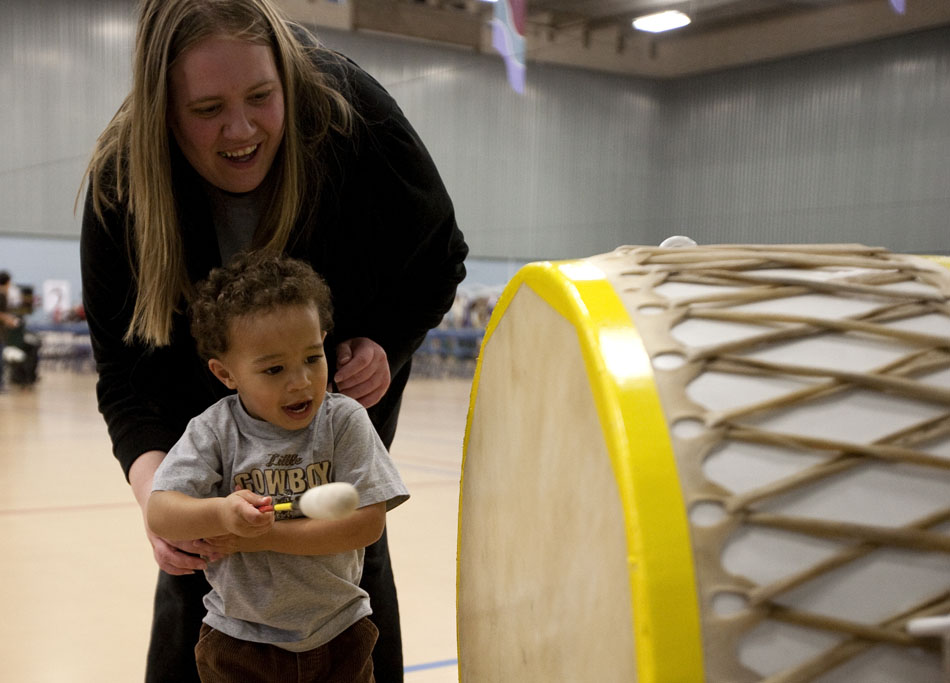 Josiah Rogers, age 2, takes a shot at playing a drum with his mom, Michelle McCune, during a traditional powwow held by the Southeast Wyoming Inter-Tribal Powwow Association (SEWIPA) on Saturday, March 26, 2011, at Laramie County Community College in Cheyenne.