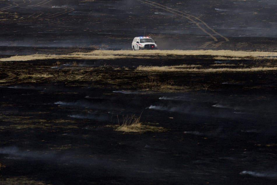 Laramie County fire fighters keep an eye on a few hotspots after a brush fire on Friday, April 1, 2011, in a field near County Road 225 north of Cheyenne. The fire burned several acres of land before fire fighters brought it under control.