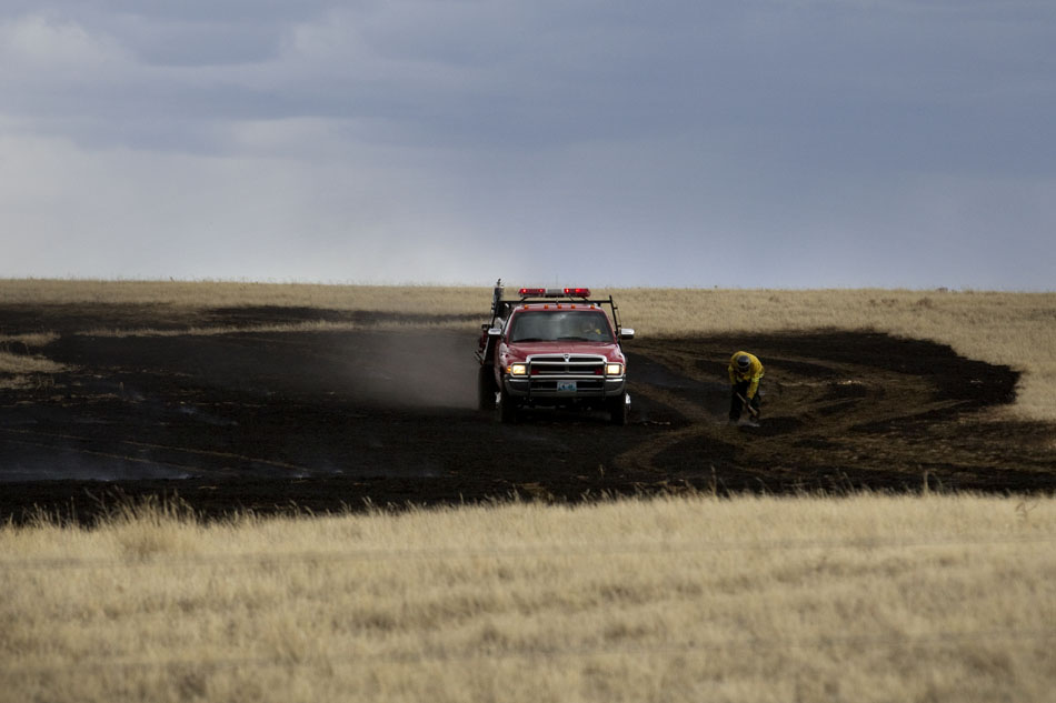 Laramie County fire fighters work to extinguish a few hotspots after a brush fire on Friday, April 1, 2011, in a field near County Road 128 north of Cheyenne. The fire burned several acres of land before fire fighters brought it under control.