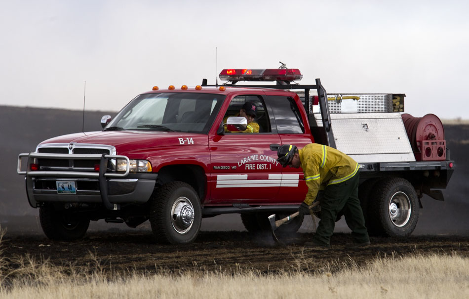 Laramie County fire fighters work to extinguish a few hotspots after a brush fire on Friday, April 1, 2011, in a field near County Road 128 north of Cheyenne. The fire burned several acres of land before fire fighters brought it under control.