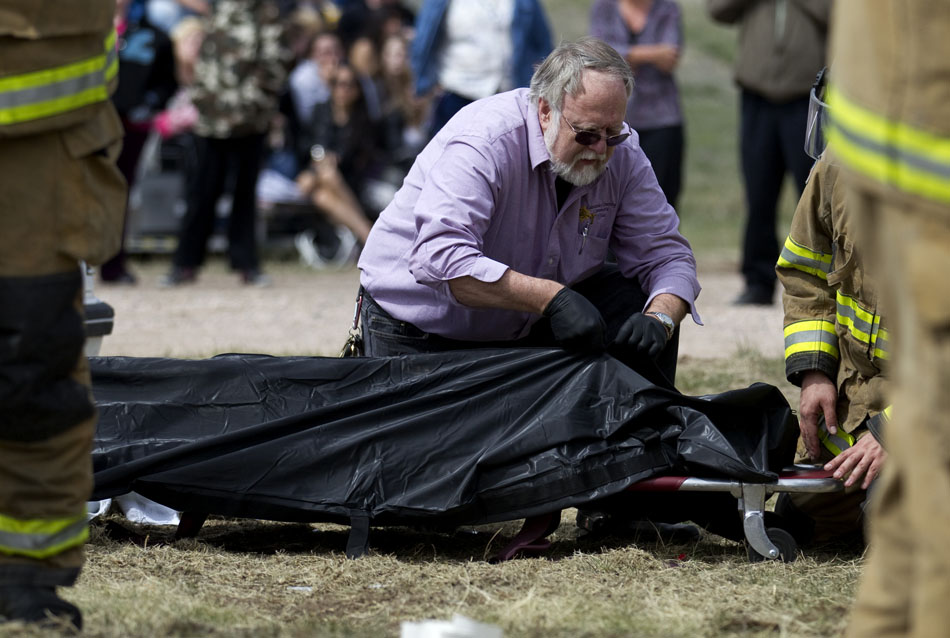 A coroner zips up a body bag during a drunken driving demonstration on Tuesday, April 12, 2011, at Okie Blanchard Stadium. The demonstration coincides with East's prom this Saturday.