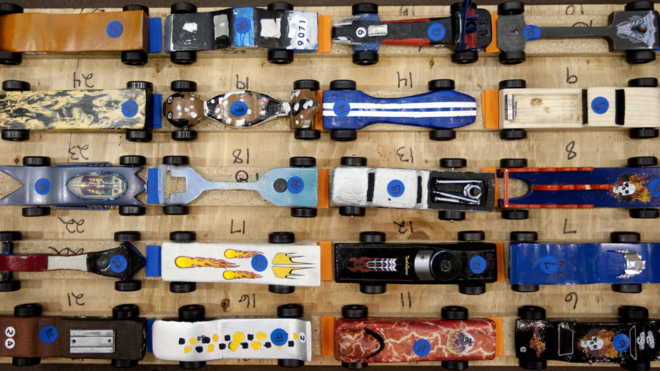 Pinewood derby entries sit on a table as volunteers prepare for the first heats on Saturday, April 23, 2011, at Storey Gym.