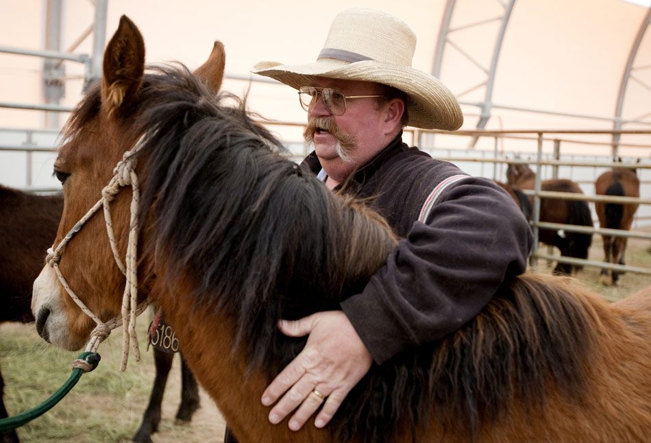 Joe Crofts, a farm manager at the Wyoming Honor Farm in Riverton, pats Della, a female wild-born horse, as he brushes pieces of straw and dirt off of her on Friday, April 29, 2011, at the Riata Ranch near Cheyenne.