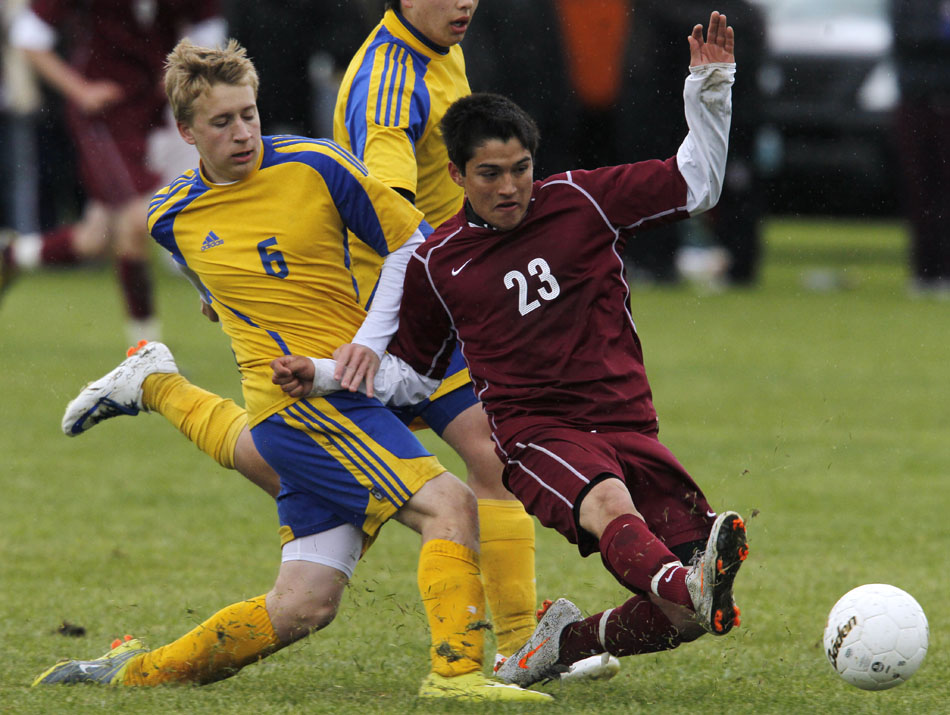 Laramie's Jimi Gomez (23) slides in to knock the ball away from Sheridan's Braydon Drell during the Class 4A boy's state soccer championship game on Saturday, May 21, 2011, in Sheridan, Wyo.