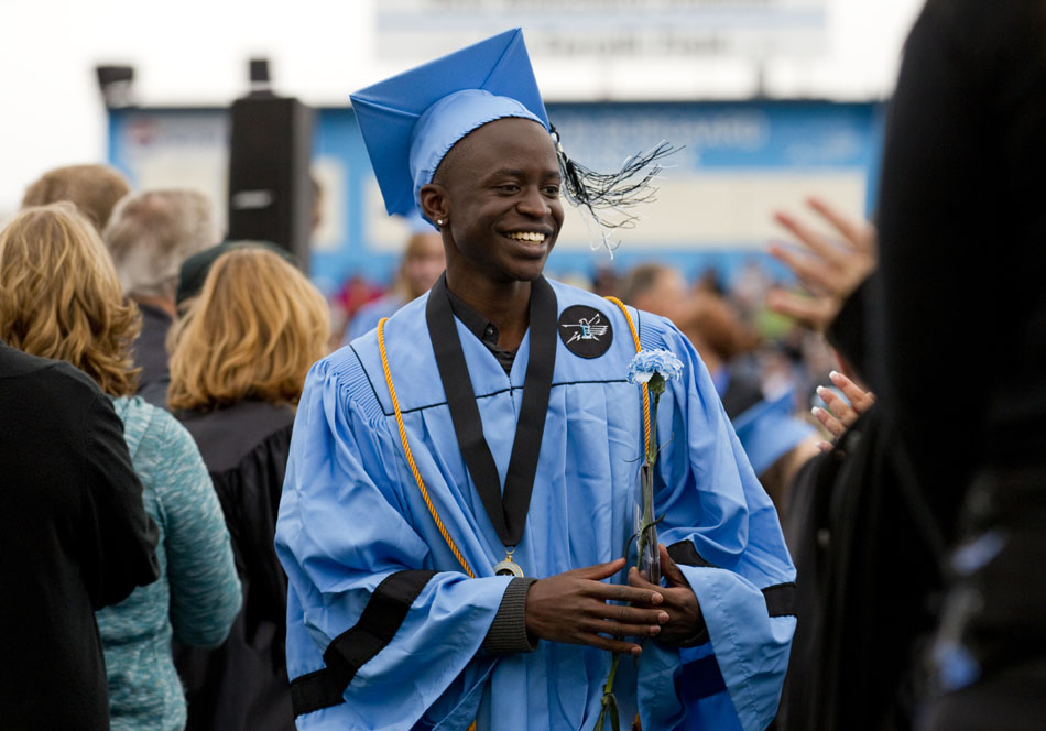 Sete Odhiambo smiles as he makes his way through a receiving line of faculty members after accepting his diploma during Cheyenne's East High School graduation on Saturday, May 28, 2011, at Okie Blanchard Stadium.