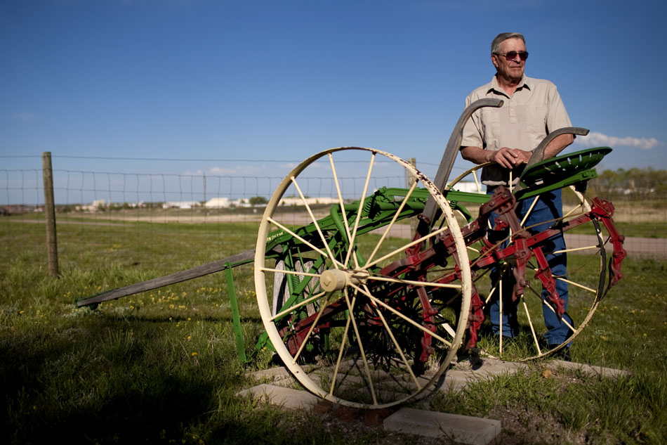 Rolf Skoetsch poses with a 1930s era John Deere row crop cultivator that adorns the yard at his Rucker Road home on Thursday, June 2, 2011. Skoetsch, who immigrated to the United States from Germany as a teenager after World War II, has a collection of antique farm equipment.