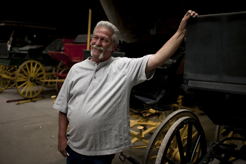 Tom Watson, the head wagon doctor, shares a laugh as he leans on one of several antique wagons in the shop on Friday, June 17, 2011, at Frontier Park. Watson has been a wagon doctor for 23 years. The wagon doctors restore and maintain antique wagons that are used in the Cheyenne Frontier Days parade each year.