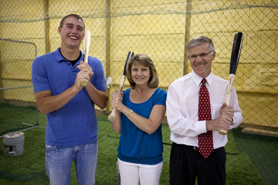 Brandon Nimmo, left, poses with his mother, Patti, and father, Ron, inside the family's 2688 sq. ft. barn on Tuesday, June 21, 2011, in Cheyenne, Wyo. The barn is home to a batting cage, pictured behind the Nimmos, where Nimmo perfected his left-handed swing growing up. (James Brosher / Special to New York Post)