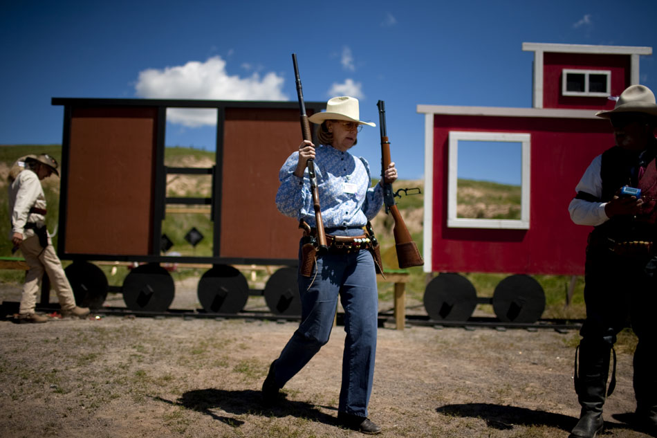 A participant walks to a table to empty her weapons after a shoot during Hell on Wheels on Friday, July 1, 2011, at the Cheyenne Regulators Range west of Cheyenne.