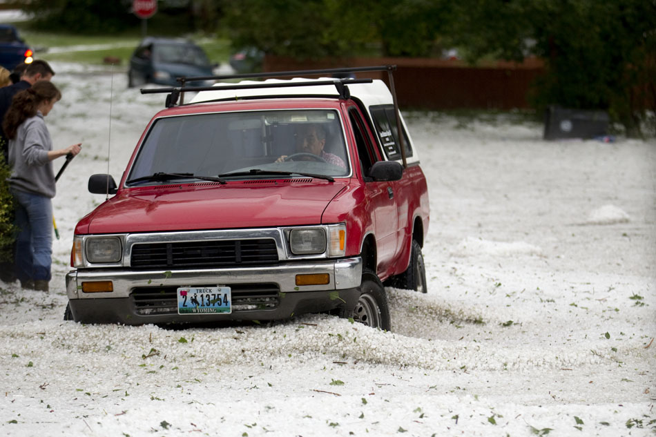 A man navigates hail-filled waters at the intersection of 23rd Street and Bradley Avenue on Tuesday, July 12, 2011, in Cheyenne.