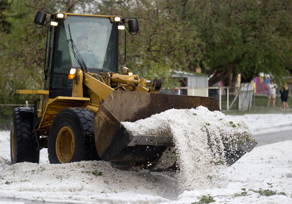 A city employee uses a front loader to clear hail, water and debris from a thunderstorm at the intersection of 23rd Street and Bradley Avenue on Tuesday, July 12, 2011, in Cheyenne.