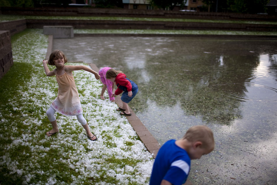 Ella Giennapp, 8, winds up to throw a piece of hail into a pond that formed at Pando Park on Tuesday, July 12, 2011, in Cheyenne. Several youngsters trekked to the park to try throwing hail into the water.