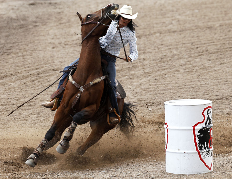 Sarah Kieckhefer from Prescott, Ariz. rounds the third barrel on her horse during the first go of barrel racing on Tuesday, July 19, 2011, at Frontier Park. Kieckhefer finished the run with a time of 18.71 seconds.