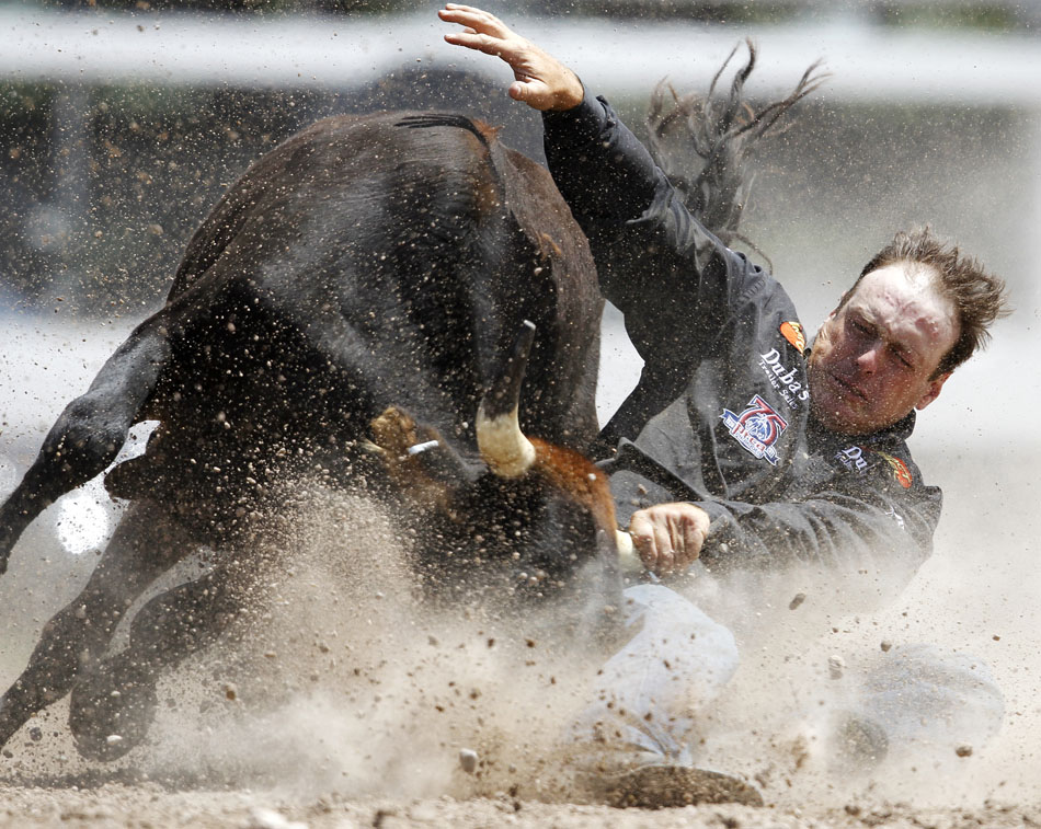 Kyle Whitaker from Chambers, Neb. wrestles a steer to the ground during the Cheyenne Frontier Days rodeo on Thursday, July 28, 2011, at Frontier Park. He logged a time of 10.8 seconds.