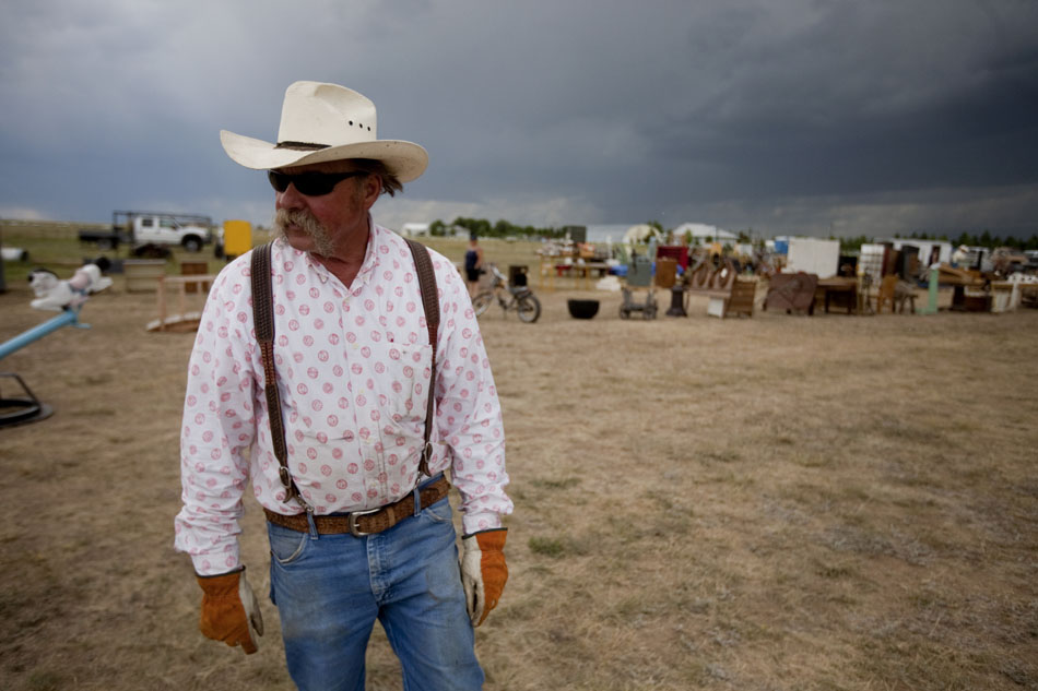 Tom Harrower talks with visitors as he stands amongst some of the items laid out for auction on Tuesday, Aug. 16, 2011, near Cheyenne. Harrower is auctioning off his lifetime collection of items that range from saddles to collector cars. The auction starts Wednesday and runs through Saturday at 8833 U.S. Highway 30 east of Cheyenne.