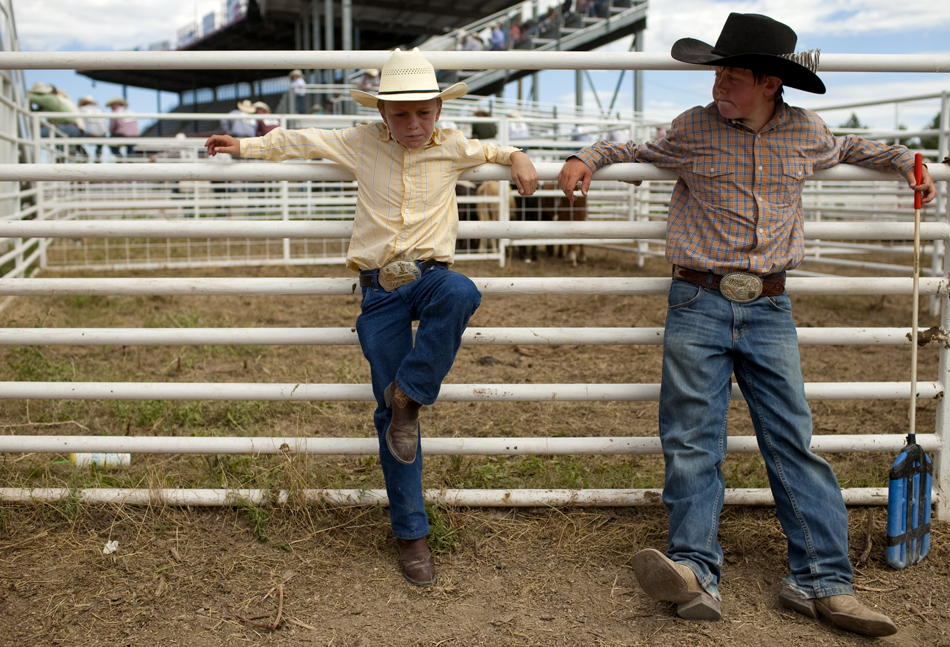Jack Osborn, left, 10, and Brayden Wiesen, 11, take a break towards the end of the day inside of a chute during the first go of slack tie-down roping on Wednesday, July 20, 2011, at Frontier Park. Several youngsters including the two funneled cattle into chute 9 from 8 a.m. to about noon for slack tie-down roping.