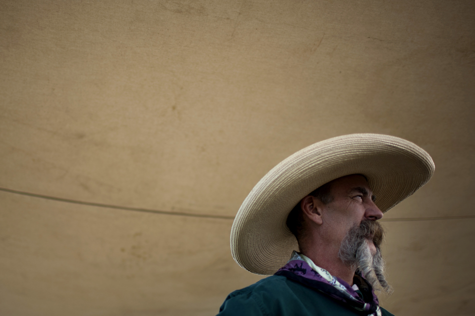 Ken Willis, of Cheyenne, listens to a conversation during a chuckwagon breakfast before the start of the Cheyenne Frontier Days cattle drive on Sunday, July 17, 2011, north of Cheyenne. Willis was serving coffee during the breakfast.