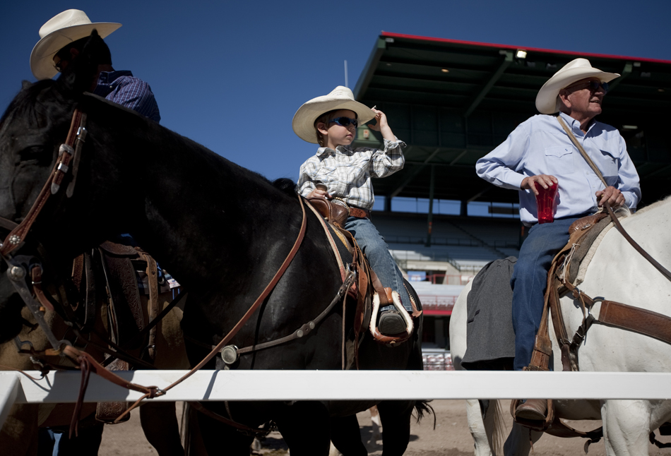 Jett Fisher, 5, sets watches the action with his father, Vin Fisher, left, and friend Ken Rockenbach during Cheyenne Frontier Days steer roping on Friday, July 22, 2011, at Frontier Park. The Fishers are from Andrews, Texas.