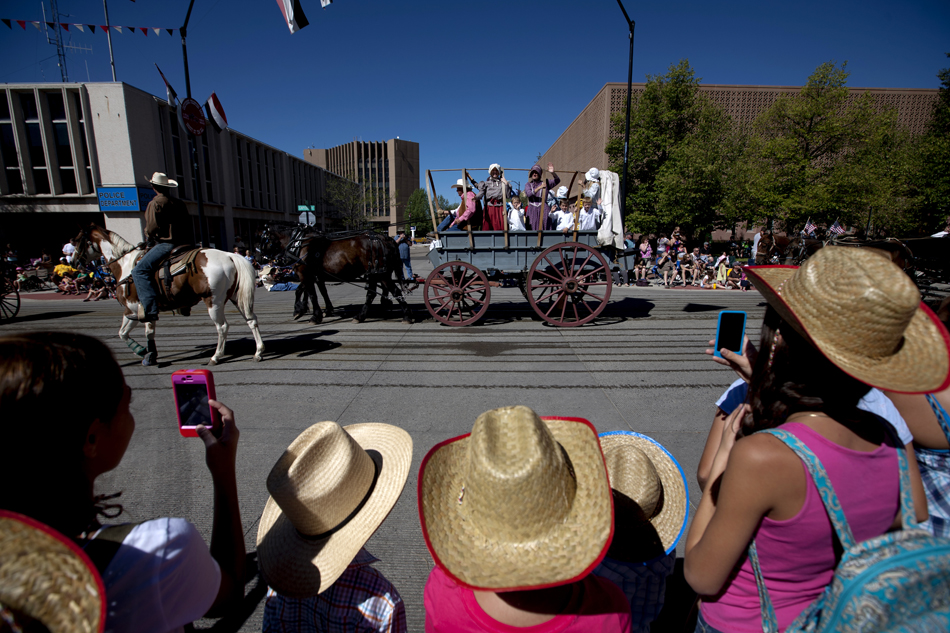 A family watches as a covered wagon passes the intersection of Capitol Avenue and 21st Street during the Cheyenne Frontier Days parade on Saturday, July 23, 2011, in downtown Cheyenne.