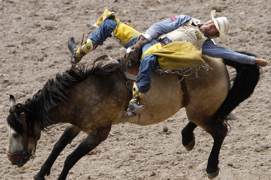 Bobby Mote from Culver, Ore. rides a bronco bareback during Cheyenne Frontier Days rodeo action on Saturday, July 23, 2011, at Frontier Park.
