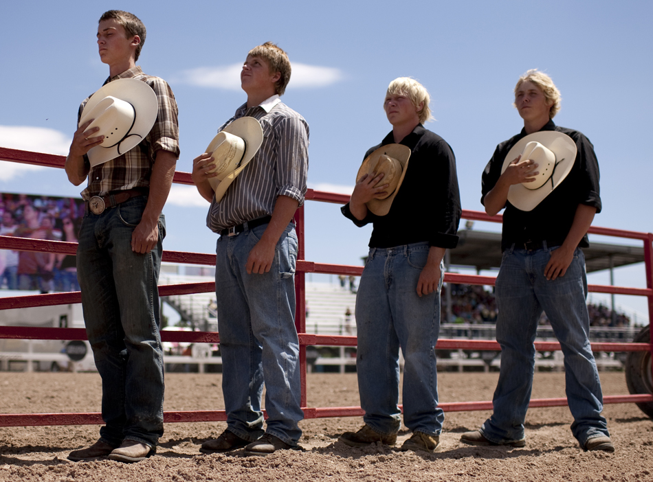 Cowboys stand for the National Anthem before the start of the Cheyenne Frontier Days rodeo on Thursday, July 28, 2011, at Frontier Park.