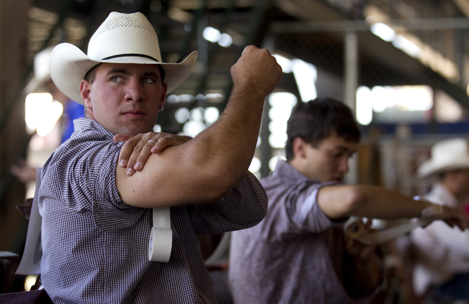 Mac Erickson from Sundance, Wyo. tapes up his arm as he gets ready for a ride behind the main chutes during the Cheyenne Frontier Days rodeo on Friday, July 29, 2011, at Frontier Park.
