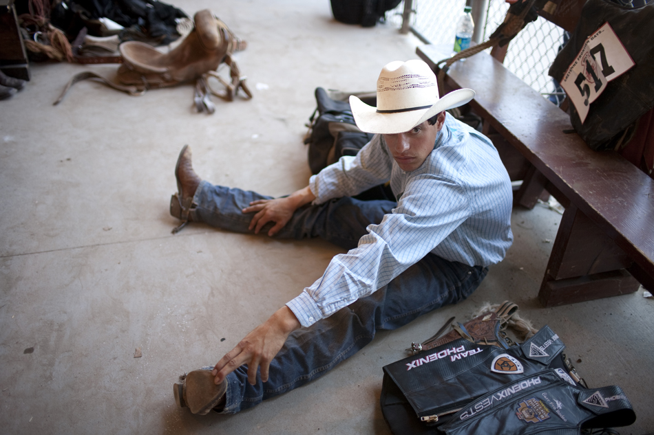 Bull rider Tater Hins from Huron, S.D. stretches out in the cowboy ready area behind the main chutes during the Cheyenne Frontier Days rodeo on Sunday, July 31, 2011, at Frontier Park.