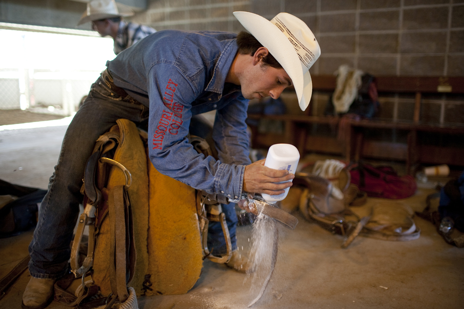 Will Smith from Marshall, Mo. uses baby powder on his saddle as he prepares for a ride in the cowboy ready area behind the main chutes during the Cheyenne Frontier Days rodeo on Sunday, July 31, 2011, at Frontier Park.