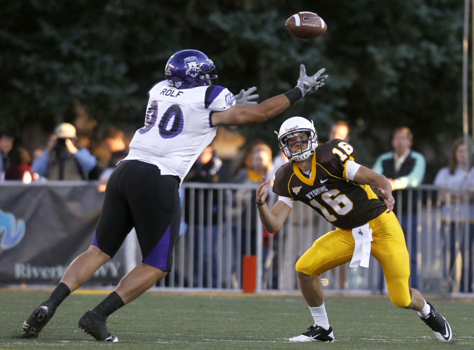 Weber State defensive end Pete Rolf (90) intercepts Wyoming quarterback Brett Smith during a NCAA college football game on Saturday, Sept. 3, 2011, at War Memorial Stadium in Laramie, Wyo.