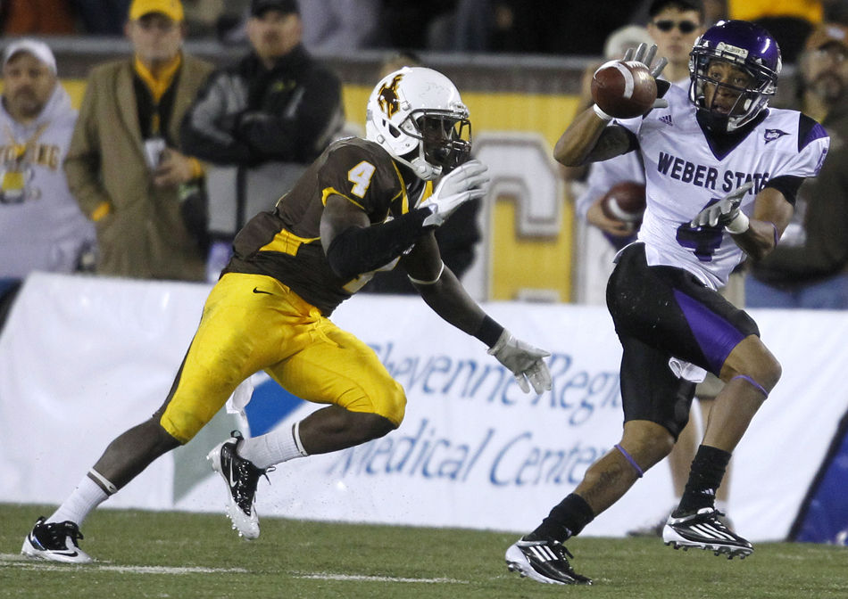 Weber State cornerback Xavian Johnson (4) catches a pass in front of Wyoming cornerback Tashaun Gipson during a NCAA college football game on Saturday, Sept. 3, 2011, at War Memorial Stadium in Laramie, Wyo. Johnson broke a tackle and scored on the play to make it a 21-19 game at the half.