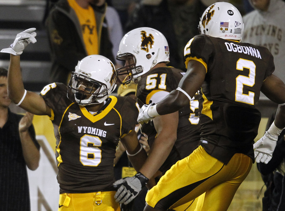 Wyoming wide receiver Robert Herron (6) celebrates with teammates guard Tyler Strong (51) and wide receiver Mazi Ogbonna (2) after  Herron hauled in a long reception during a NCAA college football game on Saturday, Sept. 3, 2011, at War Memorial Stadium in Laramie, Wyo.