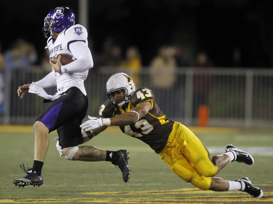 Wyoming linebacker Devyn Harris dives as he tries to catch Weber State quarterback Mike Hoke during a NCAA college football game on Saturday, Sept. 3, 2011, at War Memorial Stadium in Laramie, Wyo.