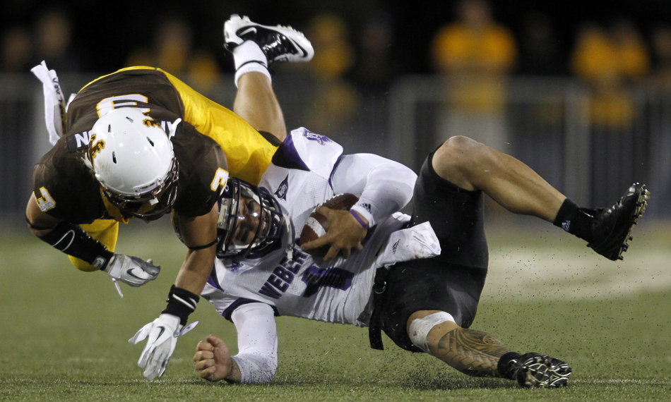 Weber State quarterback Mike Hoke reacts as he's hit by Wyoming safety Luke Anderson after a rush during a NCAA college football game on Saturday, Sept. 3, 2011, at War Memorial Stadium in Laramie, Wyo.