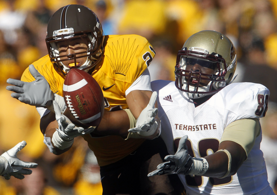 Wyoming linebacker Mark Nzeocha, left, intercepts a pass intended for Texas State tight end Chase Harper during a NCAA college football game on Saturday, Sept. 10, 2011, at War Memorial Stadium in Laramie, Wyo.