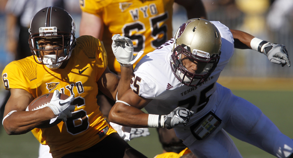 Texas State cornerback Lee Asemota, right, lays a hit on Wyoming wide receiver Robert Herron during a NCAA college football game on Saturday, Sept. 10, 2011, at War Memorial Stadium in Laramie, Wyo.