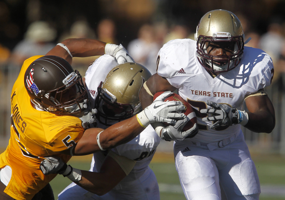 Wyoming linebacker Korey Jones, left, reaches out as he tries to tackle Texas State running back Terrence Franks during a NCAA college football game on Saturday, Sept. 10, 2011, at War Memorial Stadium in Laramie, Wyo.