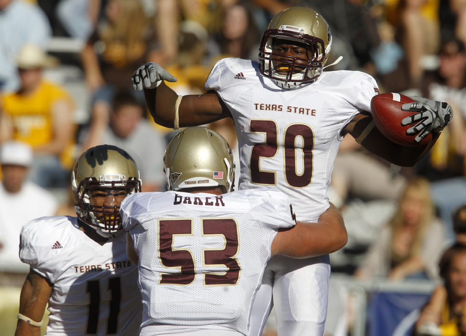 Texas State running back Terrence Franks (20) celebrates after scoring a touchdown with teammates during a NCAA college football game on Saturday, Sept. 10, 2011, at War Memorial Stadium in Laramie, Wyo.