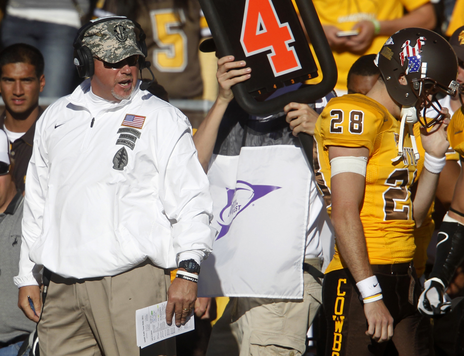 Wyoming head coach Dave Christensen, left, yells at punter Austin McCoy after McCoy kicked a punt off the side of his foot during a NCAA college football game on Saturday, Sept. 10, 2011, at War Memorial Stadium in Laramie, Wyo.