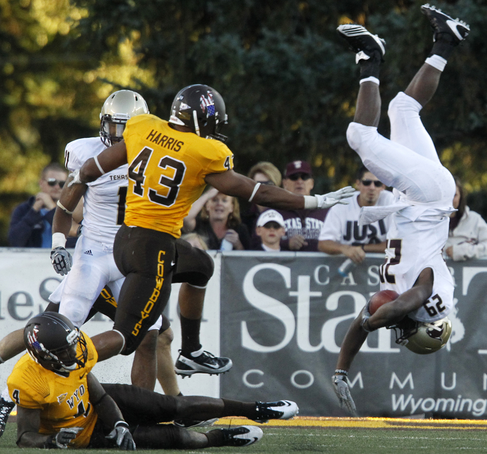 Texas State running back Chris Nutall flips upside down after a hit from Wyoming cornerback Tashaun Gipson (4) during a NCAA college football game on Saturday, Sept. 10, 2011, at War Memorial Stadium in Laramie, Wyo.
