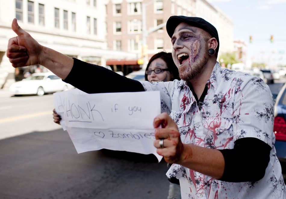 Gus White, of Cheyenne, gives a thumbs up after successfully getting a driver to honk for zombies before the start of a zombie walk on Saturday, Oct. 1, 2011, along Lincolnway in front of the Atlas Theatre.
