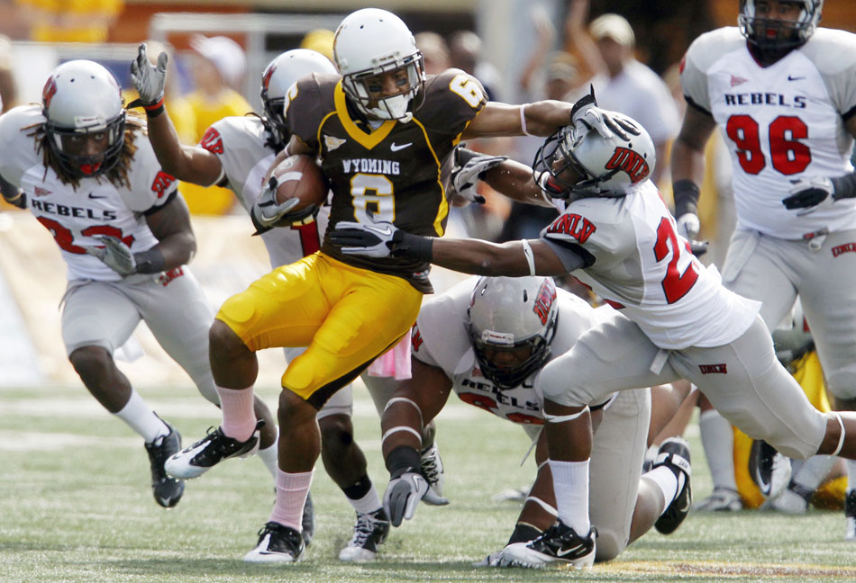Wyoming wide receiver Robert Herron (6) stiff arms UNLV defensive back Daniel Harper following a reception and run during a NCAA college football game on Saturday, Oct. 15, 2011, in Laramie, Wyo.